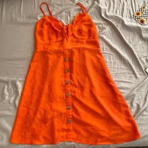 A short Orange dress that has a stretchy back